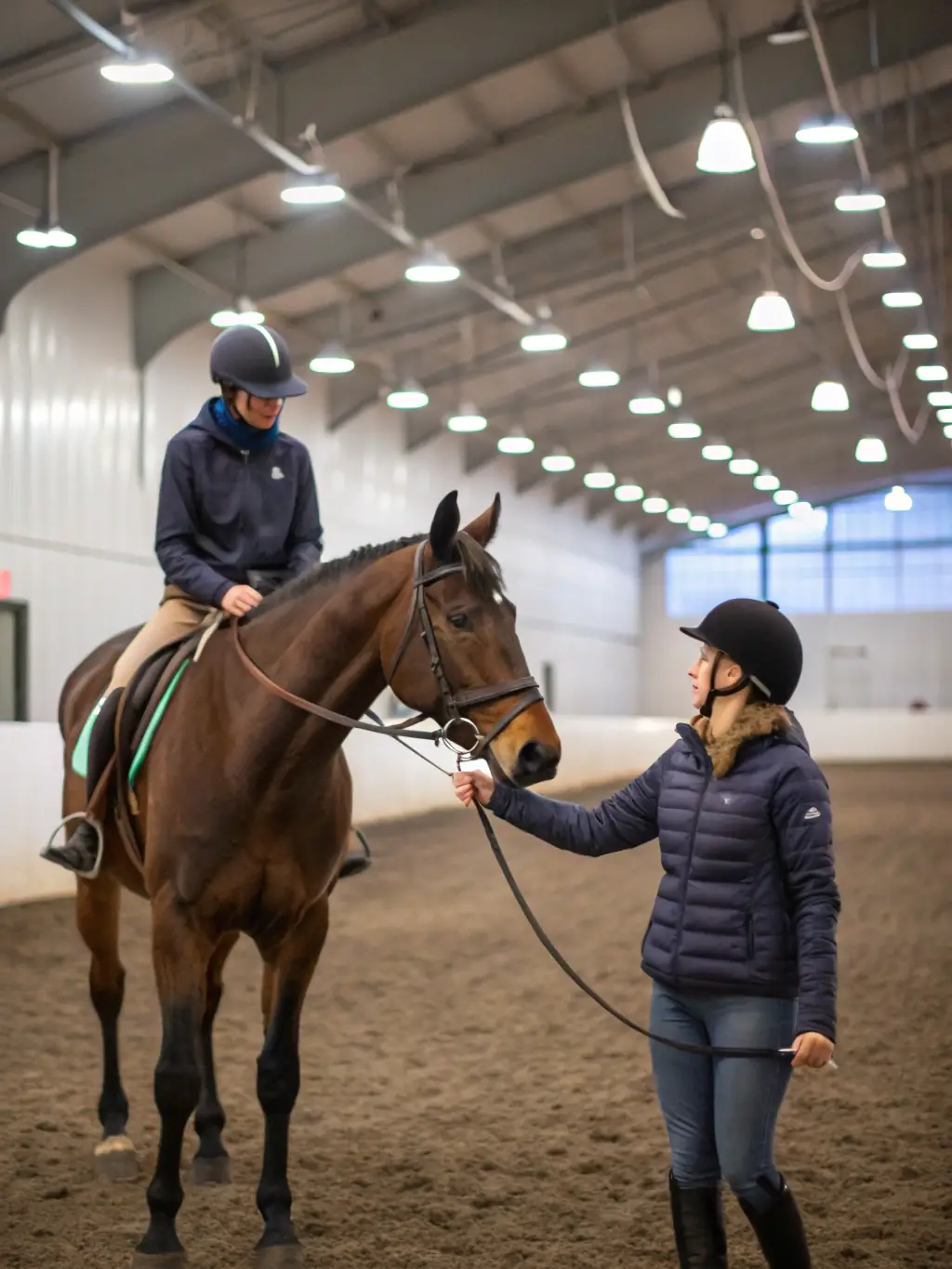 An experienced equestrian coach is providing advanced training to a rider on horseback, focusing on refining techniques and preparing for competitions at EQUI CLUB SAINT FLOUR VOLZAC.